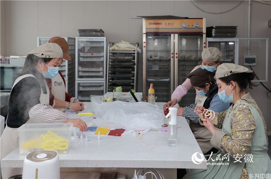 高斯雅（右一）和工人们一起制作“醒狮”花馍。人民网记者 王晓飞摄