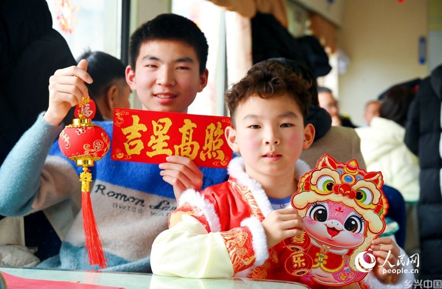 旅客在车厢内欢度小年。人民网记者 肖懿木摄