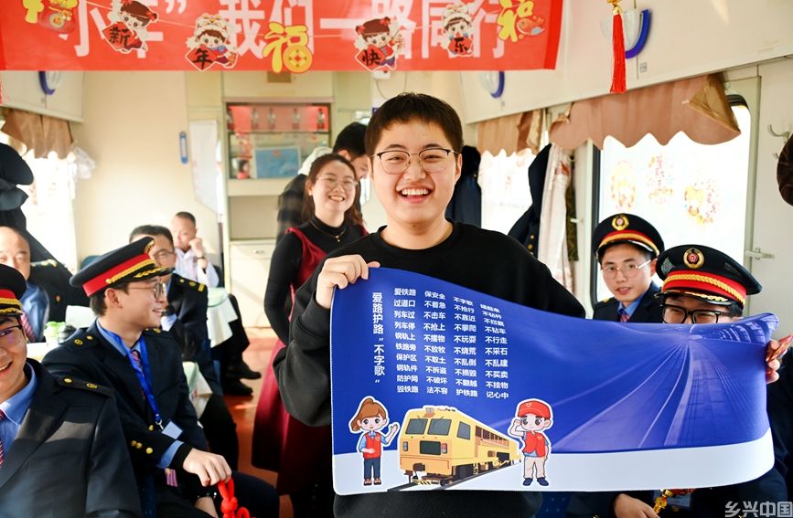 工作人员为旅客赠送铁路文创产品。祁映辰摄