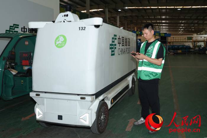 耿杰在调度无人快递物流车。人民网记者 张俊摄