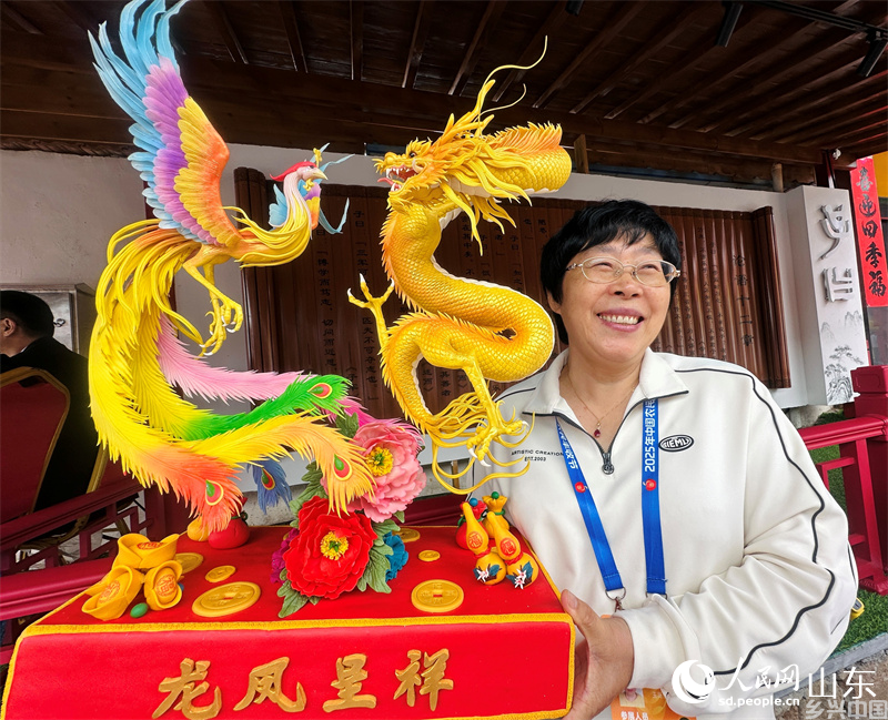 青岛王哥庄大馒头制作人展示面塑产品。人民网 乔姝摄